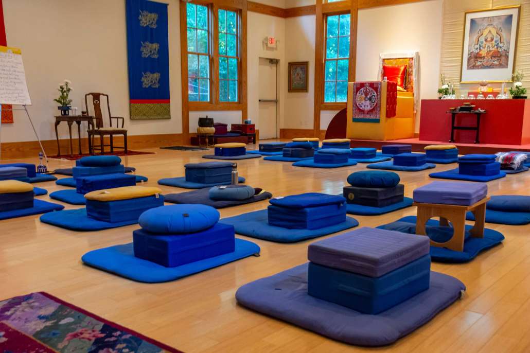 Coussins et sièges de méditation dans une salle de pratique de tradition tibétaine