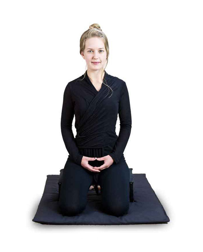 Femme en méditation assise sur ses genoux en position de seiza