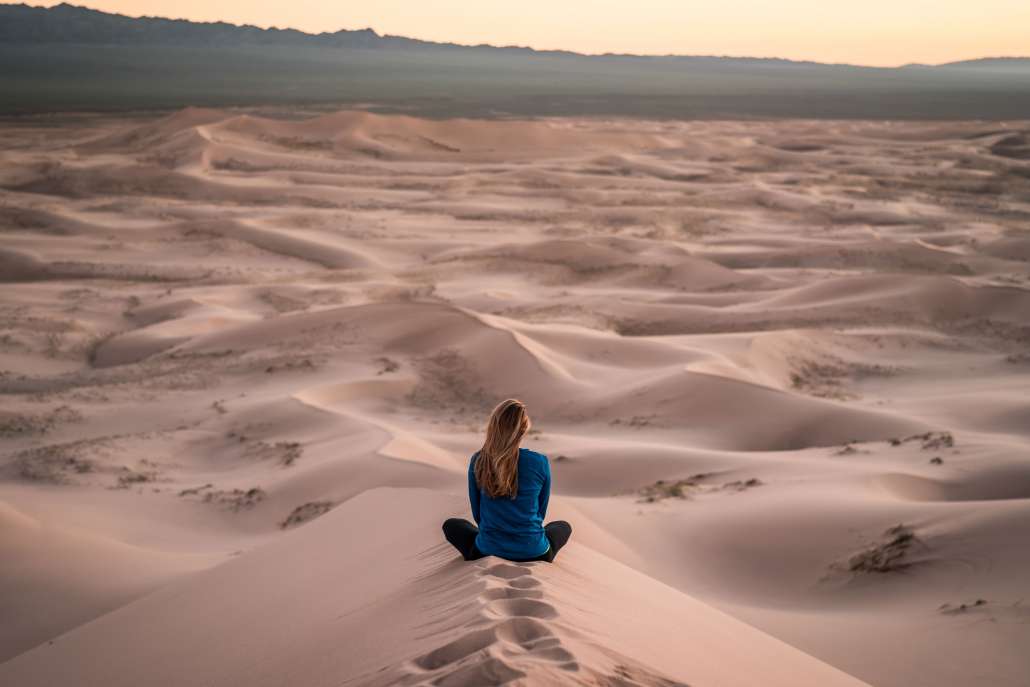 Seated woman contemplating a desert landscape