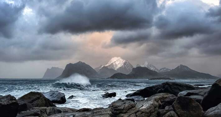 view of snowy mountain over stormy sea